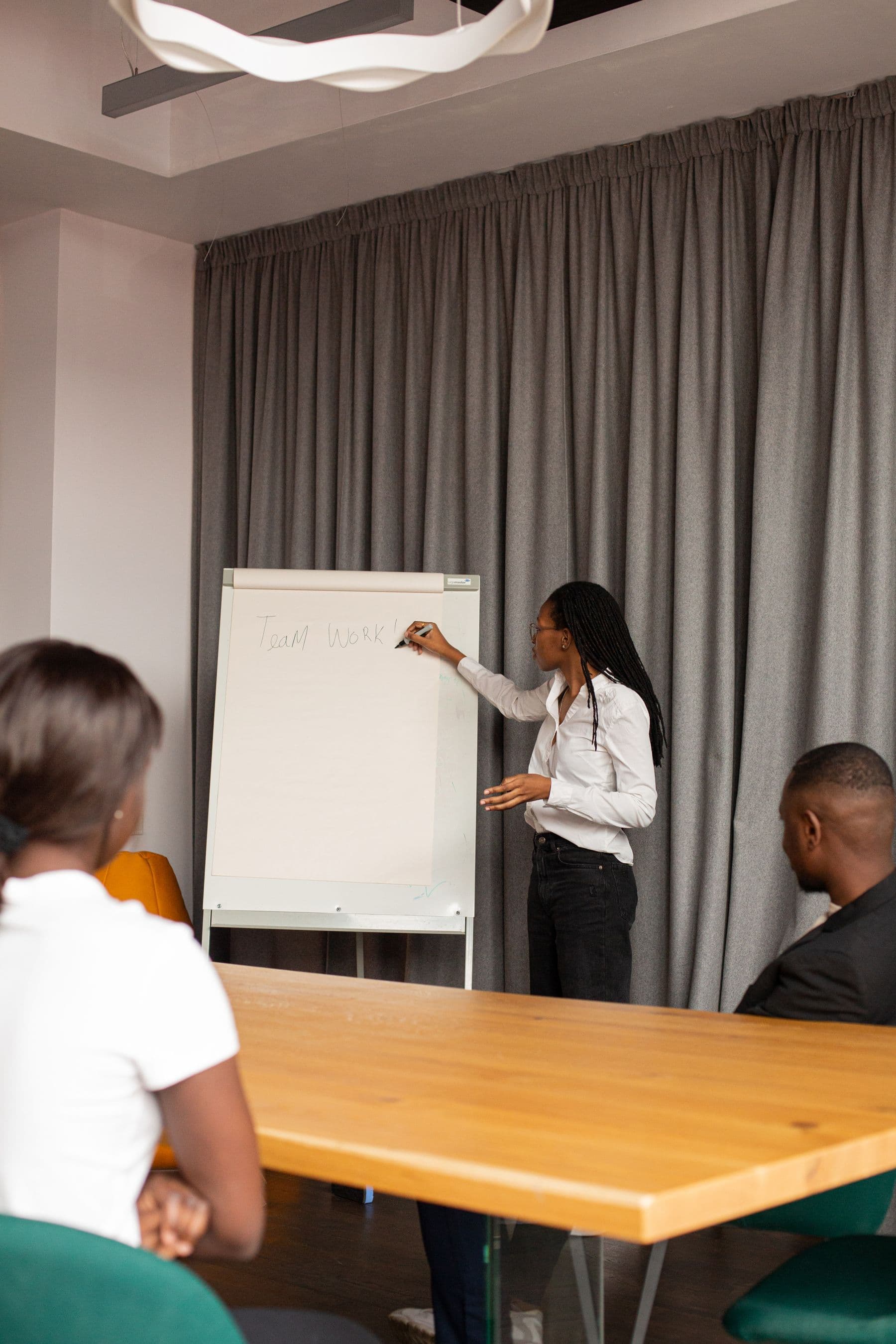 A trainer leading a small group session at a flip chart.